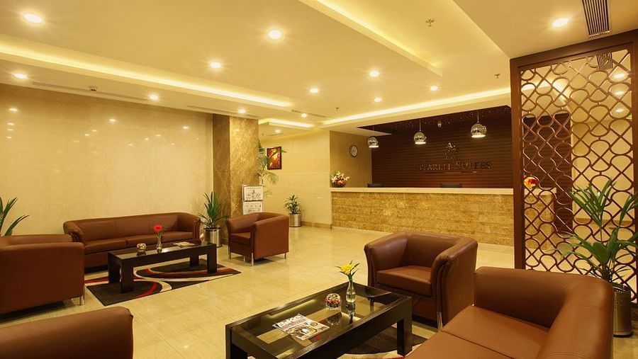 Lobby seating with the reception in view - Starlit Suites, Kochi