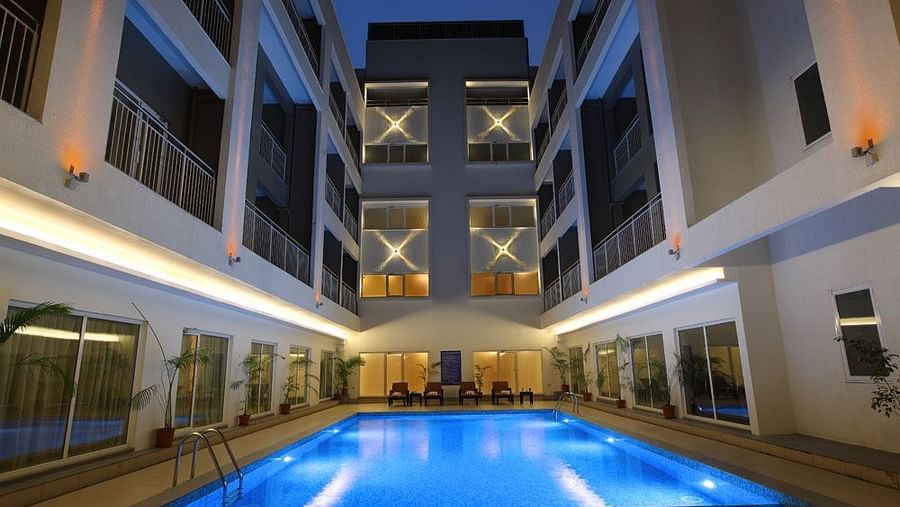 Swimming pool in the night with the lights on - Starlit Suites, Kochi