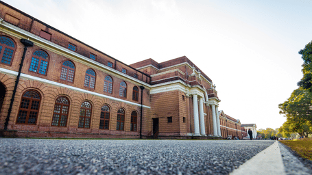 A wide shot of an old brick building with an archway.