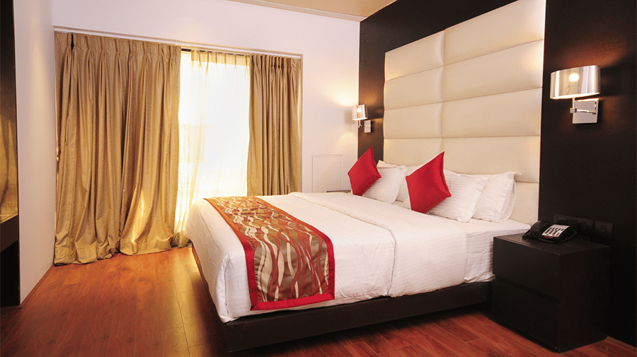 Corner view shot of the double bed in the Premier Suite with ample of natural light coming from the large window in the room - Senses Hotel