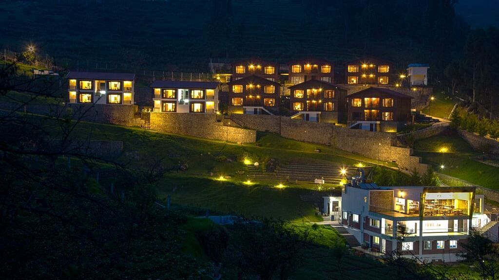 A drone shot of the GReaT Trails Kodaikanal By GRT Hotels property in the night where the property is brightly lit by lights