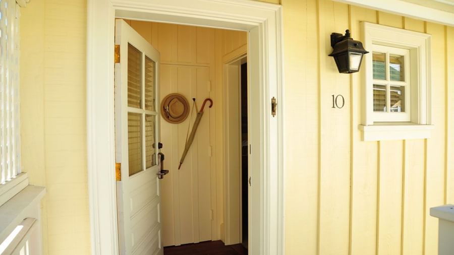 A wooden front door of a house with a small window inset at Tallman Hotel.