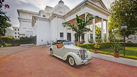A facade image of Grishma Nivas with a vintage car at the entrance