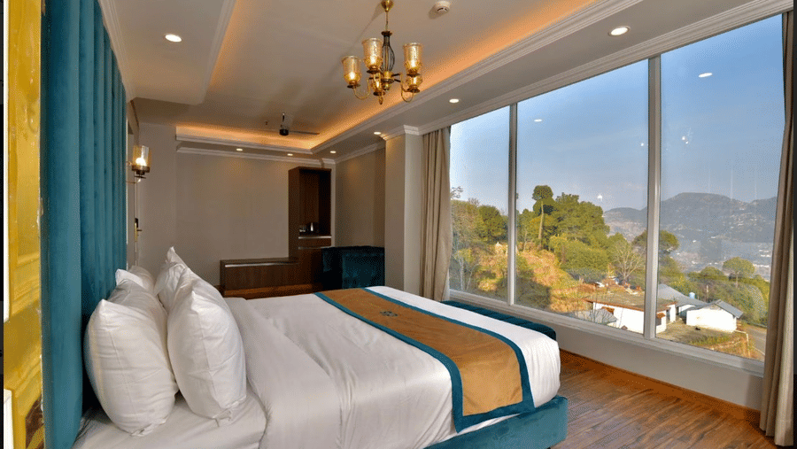 Claret Inn, Dalhousie - Room with a bed, blue curtains, large windows, and view of trees and buildings outside.