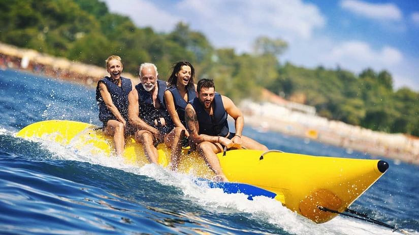 a group of people riding a banana boat near the beach