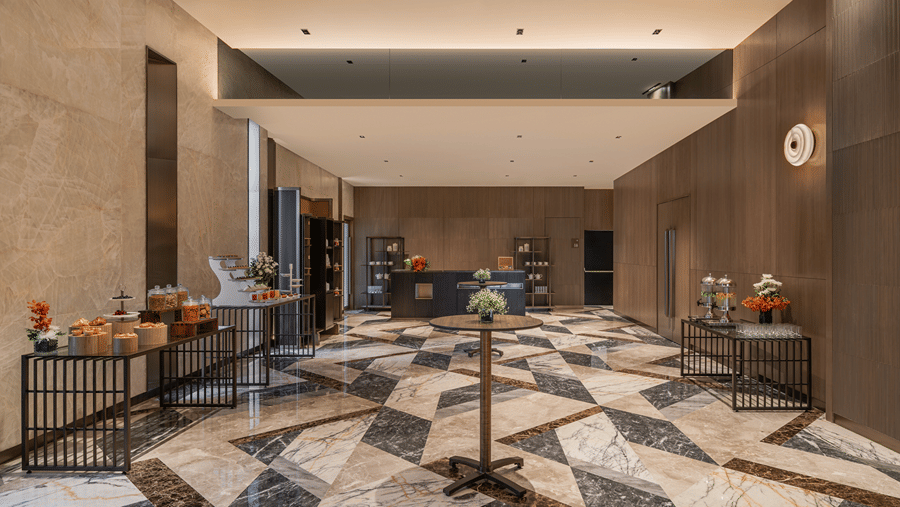 A spacious pre-function foyer featuring geometric marble flooring, refreshment tables, and modern wall decor at level 3 of The Residency Towers Chennai.