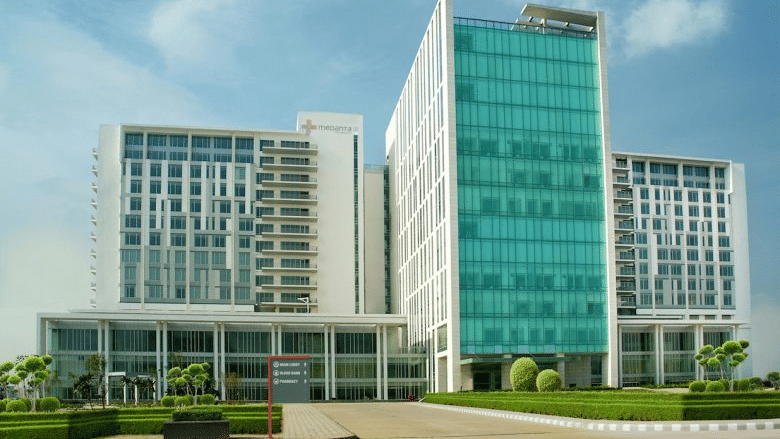 Contemporary hospital campus with glass façade and landscaped surroundings.