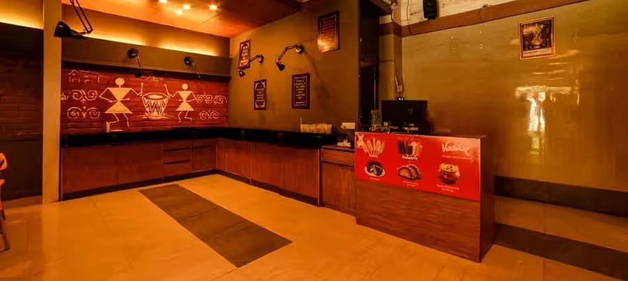 View of the entrance area with warm lighting to Mumbai Masala Restaurant - Max Hotel Prayagraj.