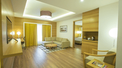 Image of suite at The Residency Towers Coimbatore featuring the living room with seating areas and a large window next to the sofa
