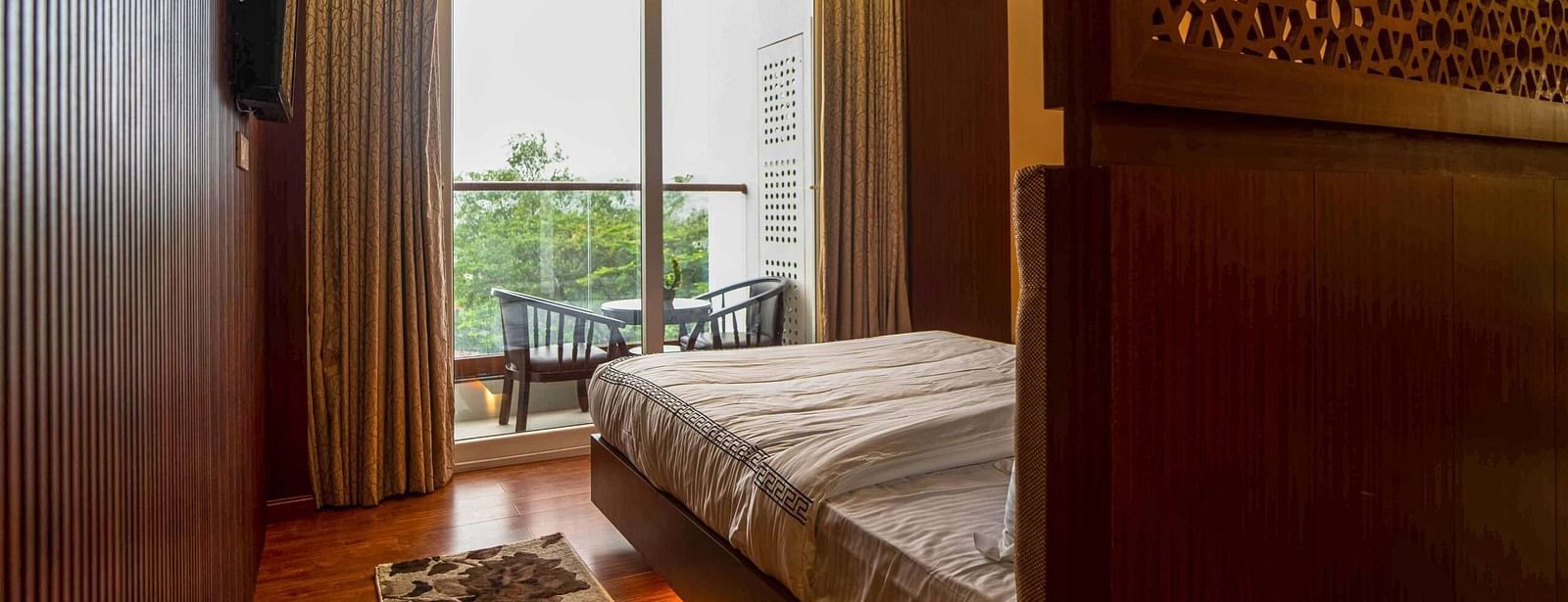 A stylish bedroom at Mansha Palace features a comfortable bed and a balcony with outdoor seating.