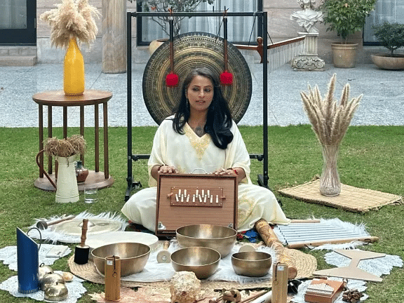 Spiritual setup on the lawn with decor, and a person seated nearby at Karma Chalets.