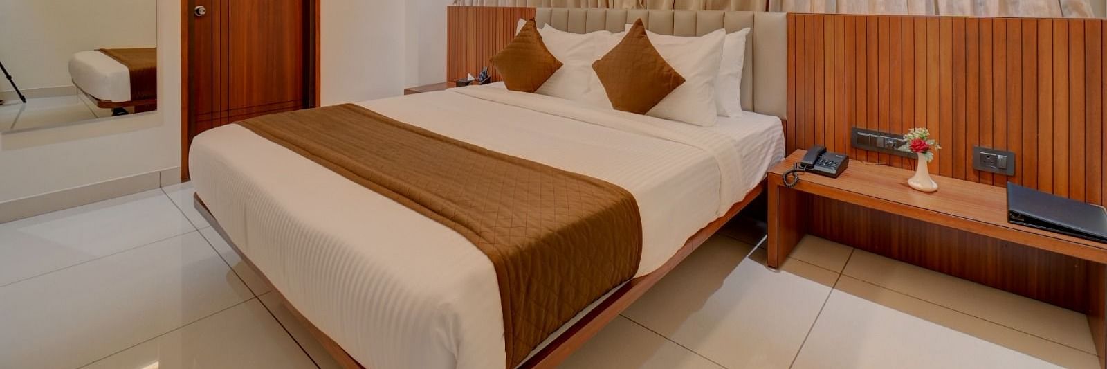 Image of a room with a bed and a door on the side at Hari Govindas, Siddappa Square.