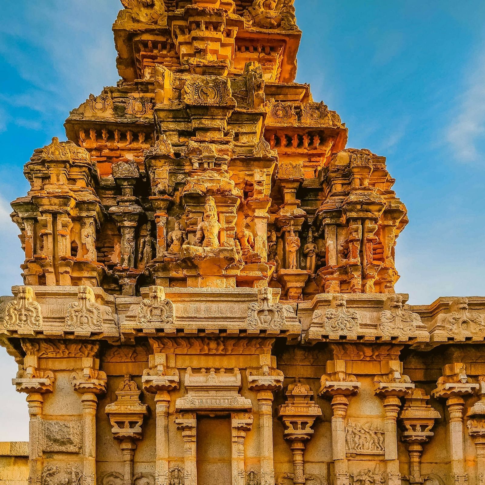 Exterior view of a temple showcasing intricate and detailed sculptures on the pillars.