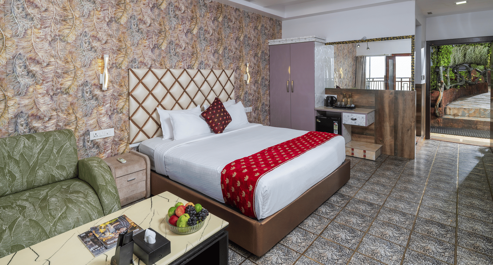 A bedroom of the Premium Club Suite at Parakkat Nature Hotel and Resorts, Munnar, featuring a large bed with decorative textiles, a ceiling fan, wood accents, and large windows opening onto outdoor greenery.