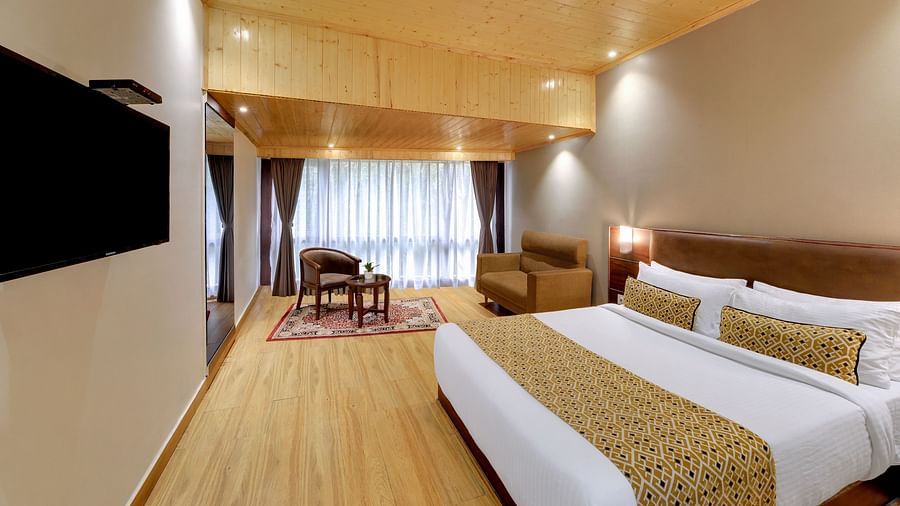 Side view of a double bed and a TV in the Premium Room at Hotel Sumitel Vista T.V Tower 