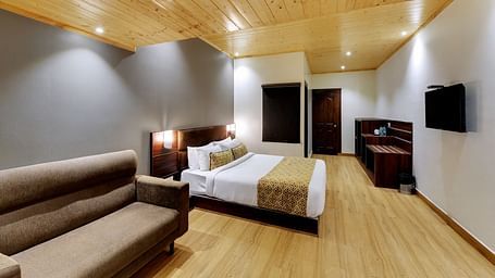 An image of a room with a queen size bed, TV, sofa, lamps and minimal decoration - Sumitel Vista TV Tower