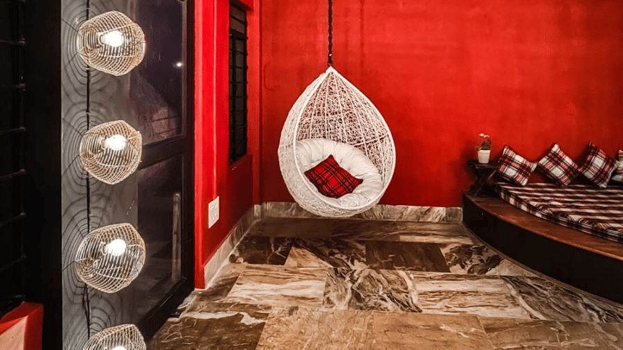 The banquet hall at Woodstock Farmhouse, Shillong, featuring a swing, and lights.