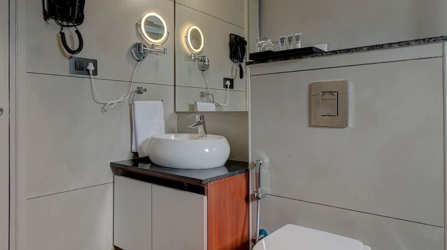 Image of a washroom with a sink and a toilet beside it at Hari Govindas, Siddappa Square.