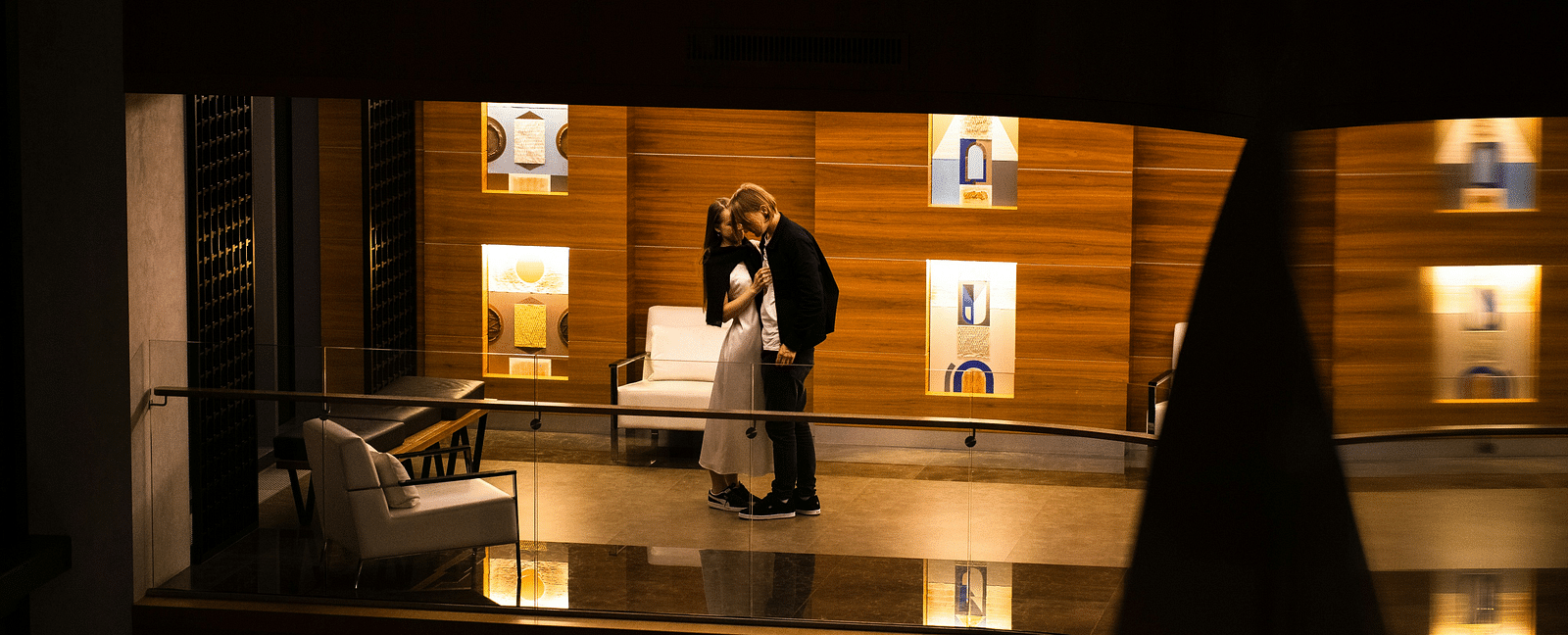 A couple being intimate in a hotel's balcony as seen from a far