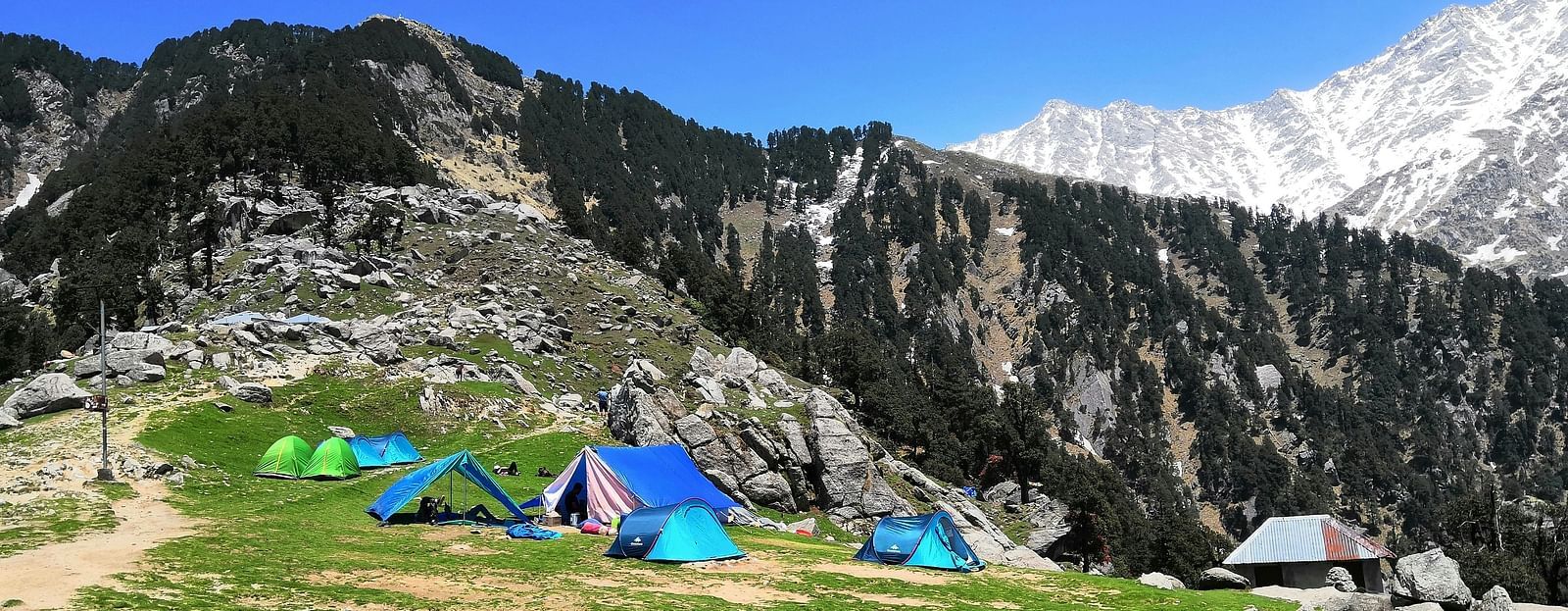 An image of a mountain where few tents are made for camping