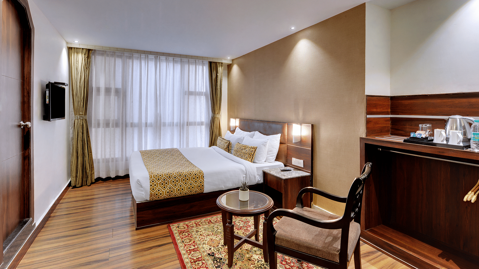 An image of a room with a queen size bed, TV, chair and a table, and room amenities like tea coffee maker - Sumitel Vista TV Tower