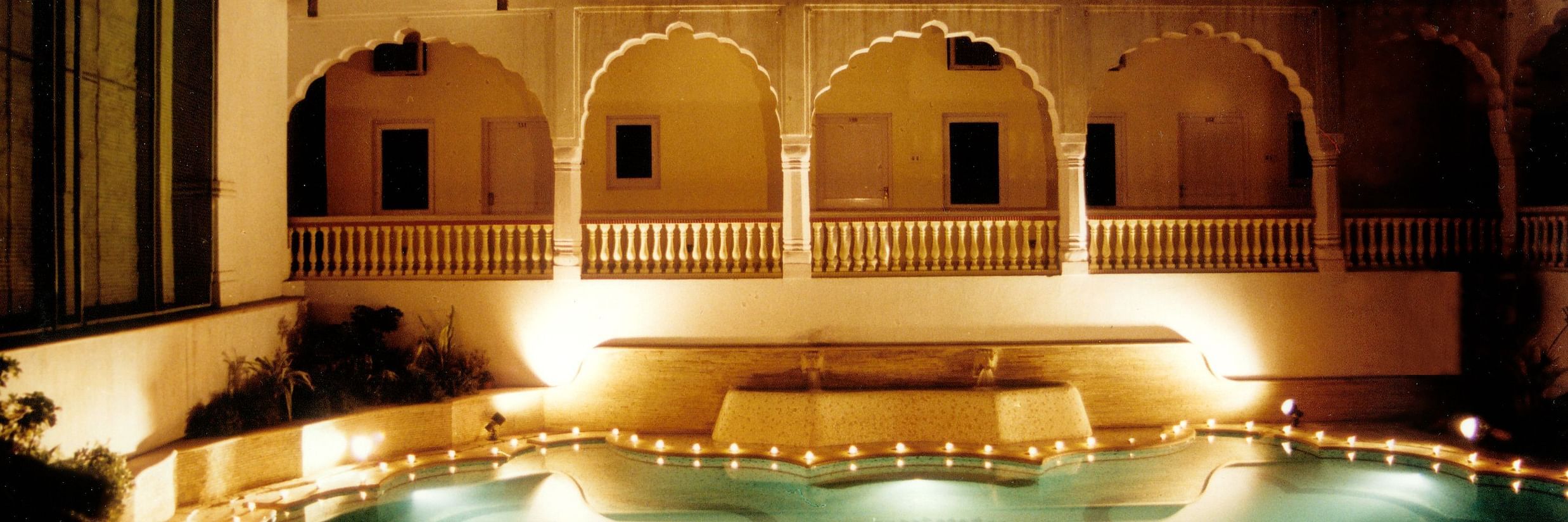 Swimming pool in the night with Mandawa Haveli, Jaipur in the background