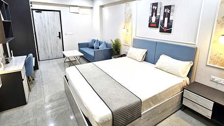 Spacious and elegantly designed studio room featuring a plush bed with a soft headboard, a cosy seating area with a modern sofa, a sleek work desk, and stylish décor - Urban Suites by BluSalzz, Jaipur