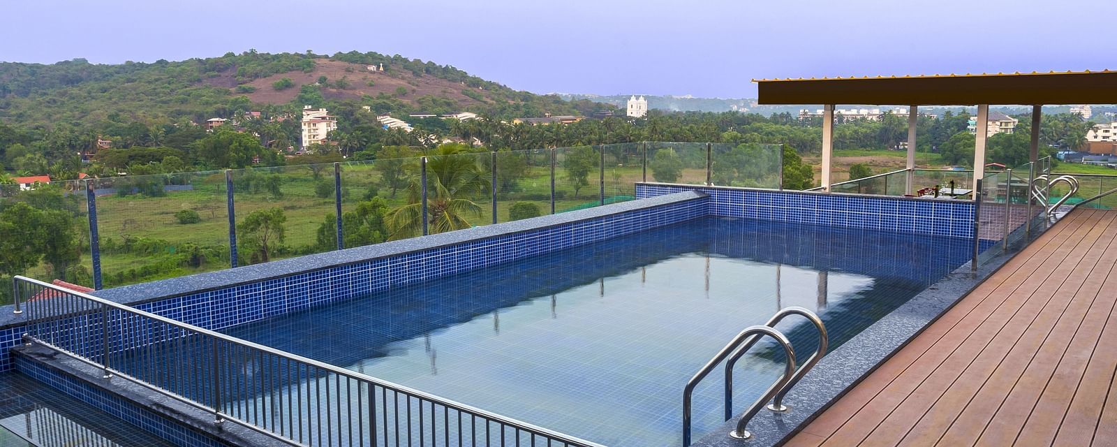 Overview of the swimming pool with a walking deck next to it - The Tanisi Hotels & Resorts, Goa