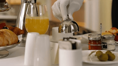 Image of a person with gloves serving food on  a table
