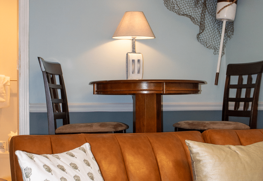 A cozy seating area with a round table, chairs, and a couch.