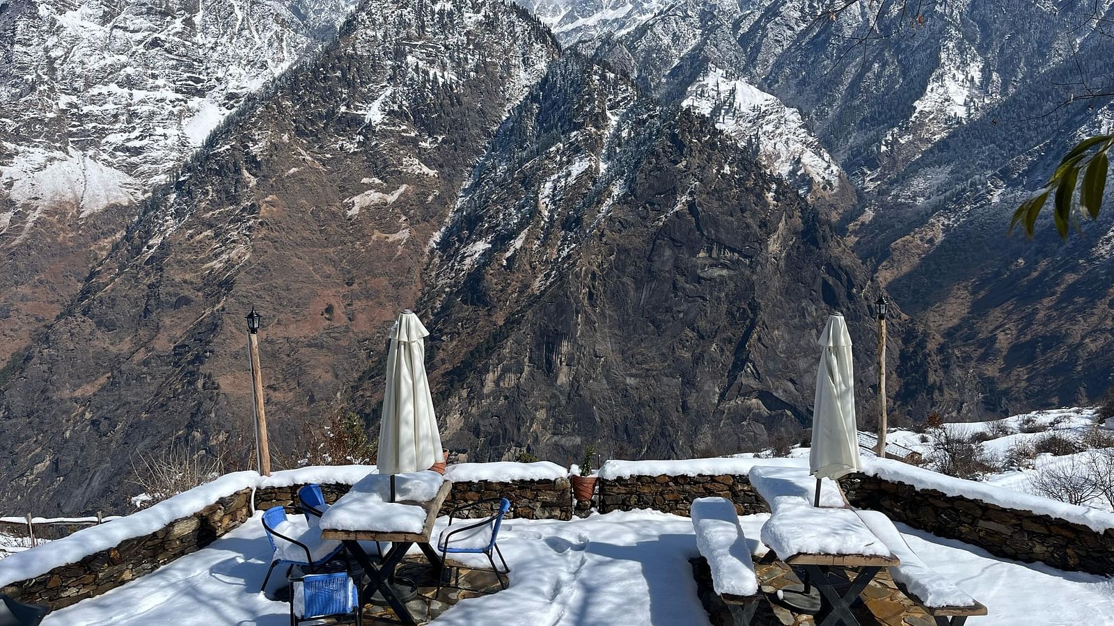 Image of outdoor seating area filled with snow and mountains in the background | Faraway Cottages, Auli