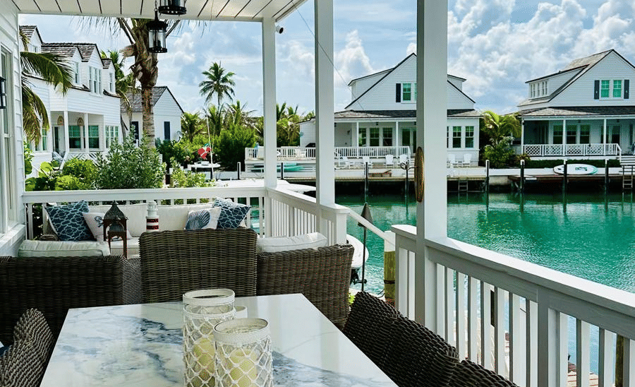 A view of a outdoor seating area with long table, multiple chairs, and a picturesque view at Elbow Room Villa 7 in Abaco inn