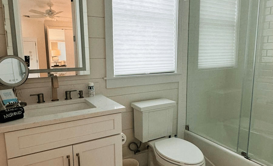 A view of a washroom at Elbow Room Villa 7 in Abaco inn with a large window, a framed mirror, and wooden flooring