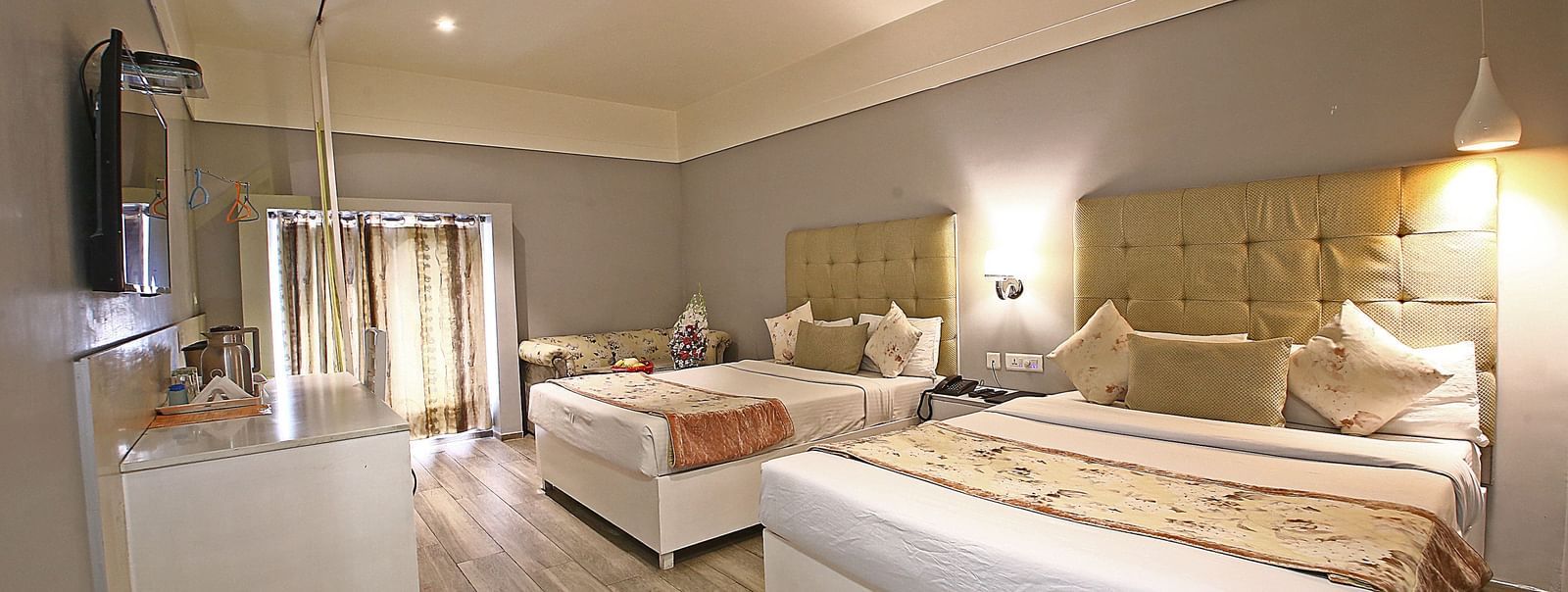 Spacious hotel room with twin beds, wardrobe, and natural light at Hotel Emerald