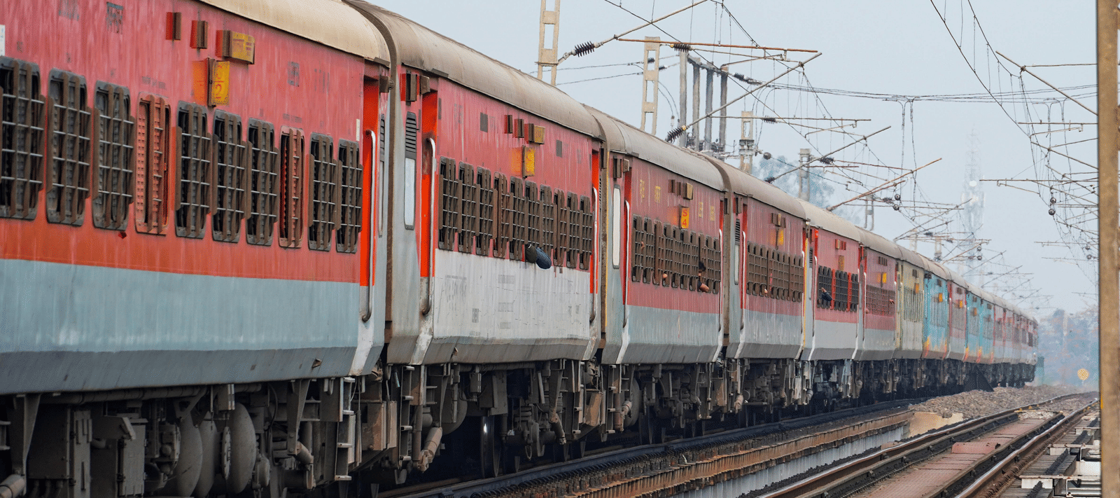 An Indian passenger train running on the railway track during the daytime