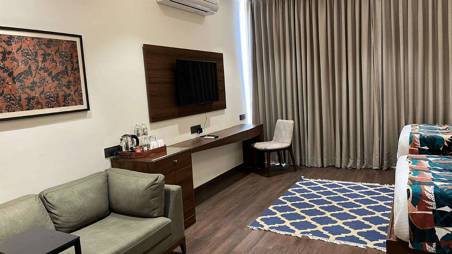 premium city twin bed room view with comfortable sofas and TV at Aura Boutique Hotel, Udaipur