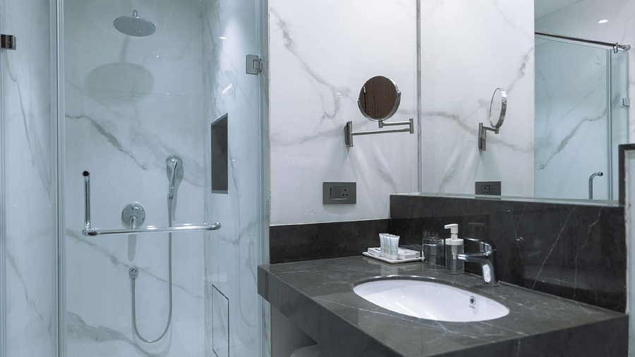 a view of the washroom with wash basin and shower facilities of  premium palace view twin bed  room at Aura Boutique Hotel, Udaipur