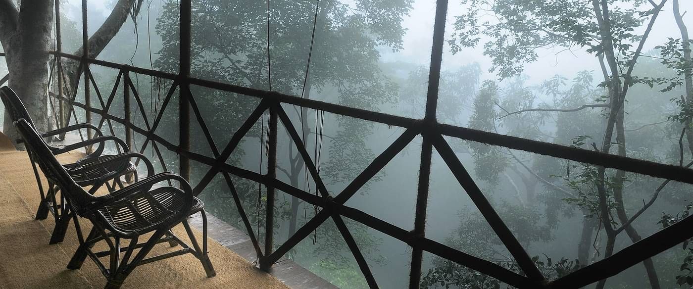 Two chairs in a balcony with forest views | Vythiri Resort. Wayanad