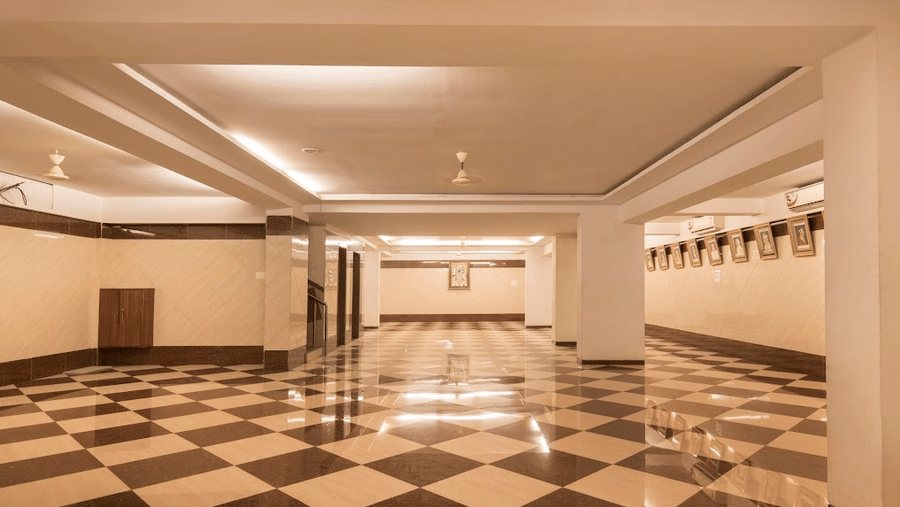 Large, open banquet event space featuring prominent pillars, white walls, and an expansive checkered floor.
