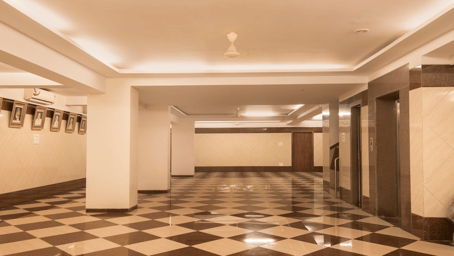 Wide angle shot of a clean, empty conference or banquet hall with distinct brown and white tiled floors.