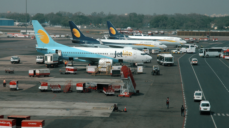 An airport road with a few planes halted.