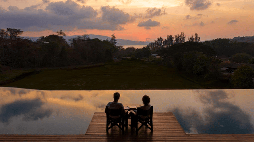 a couple sitting poolside at the sunset lounge at dusk - Symphony Samudra Beachside Jungle Resort And Spa, Port Blair