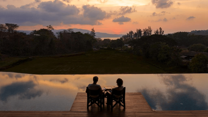 a couple sitting poolside at the sunset lounge at dusk - Symphony Samudra Beachside Jungle Resort And Spa, Port Blair
