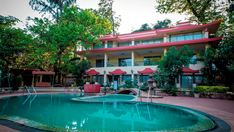 Adamo Matheran Resort - view of the swimming pool with the hotel in Matheran behind it overlooking