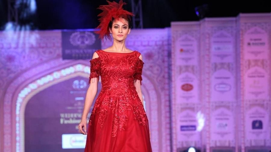 a model wearing a red dress walking the ramp - Buena Vista Luxury Garden Spa Resort 