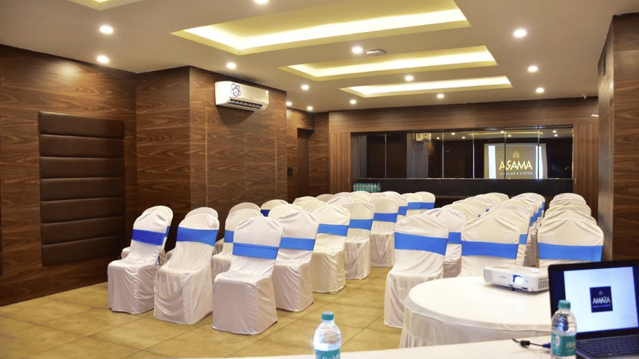 A table with a laptop placed on it and chairs in front at Amara Grand Baga, Goa.
