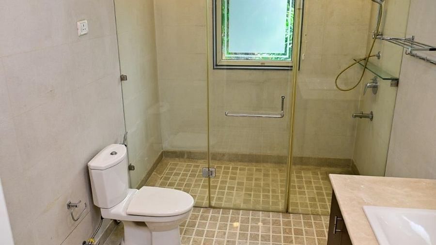 Shot of fully equipped washroom with a glass door that separates the shower area from the basin and commode | Udman Luxe Villa