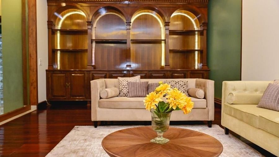 Shot of the living room of the villa featuring cosy pastel coloured sofas, a round wooden table with a flower vase | Udman Luxe Villa