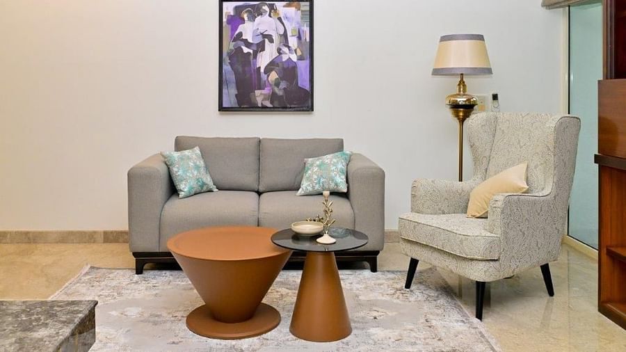 Shot of one single seater and one  a double seater couch with a round table at the centre  | Udman Luxe Villa