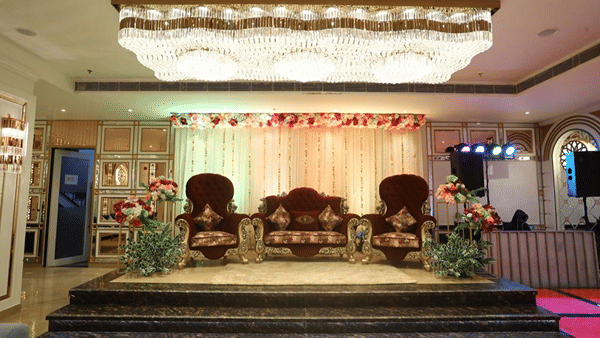 Decorated wedding stage with ornate chairs in the banquet hall.